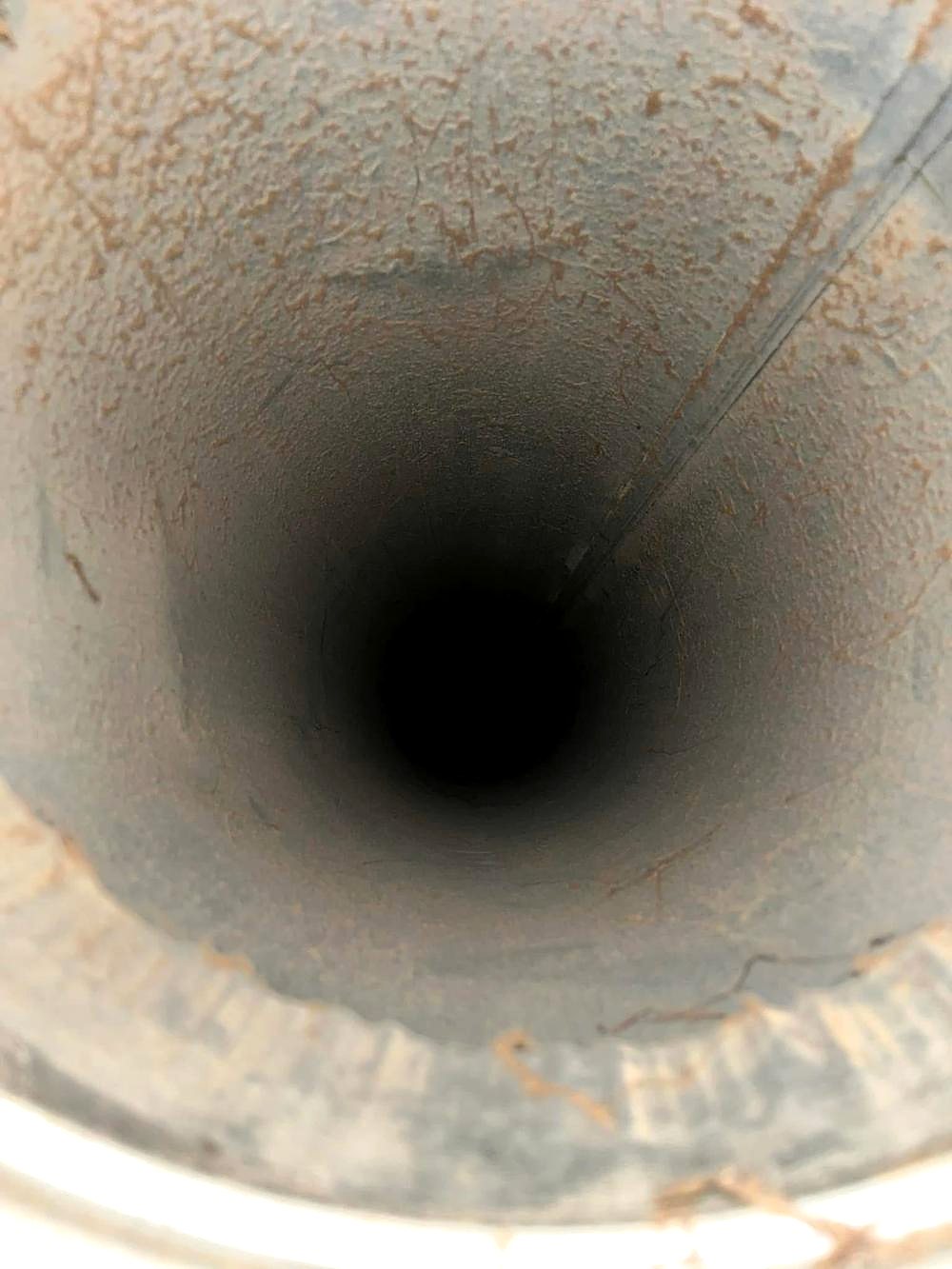 Inside a home air duct coated with dust before cleaning