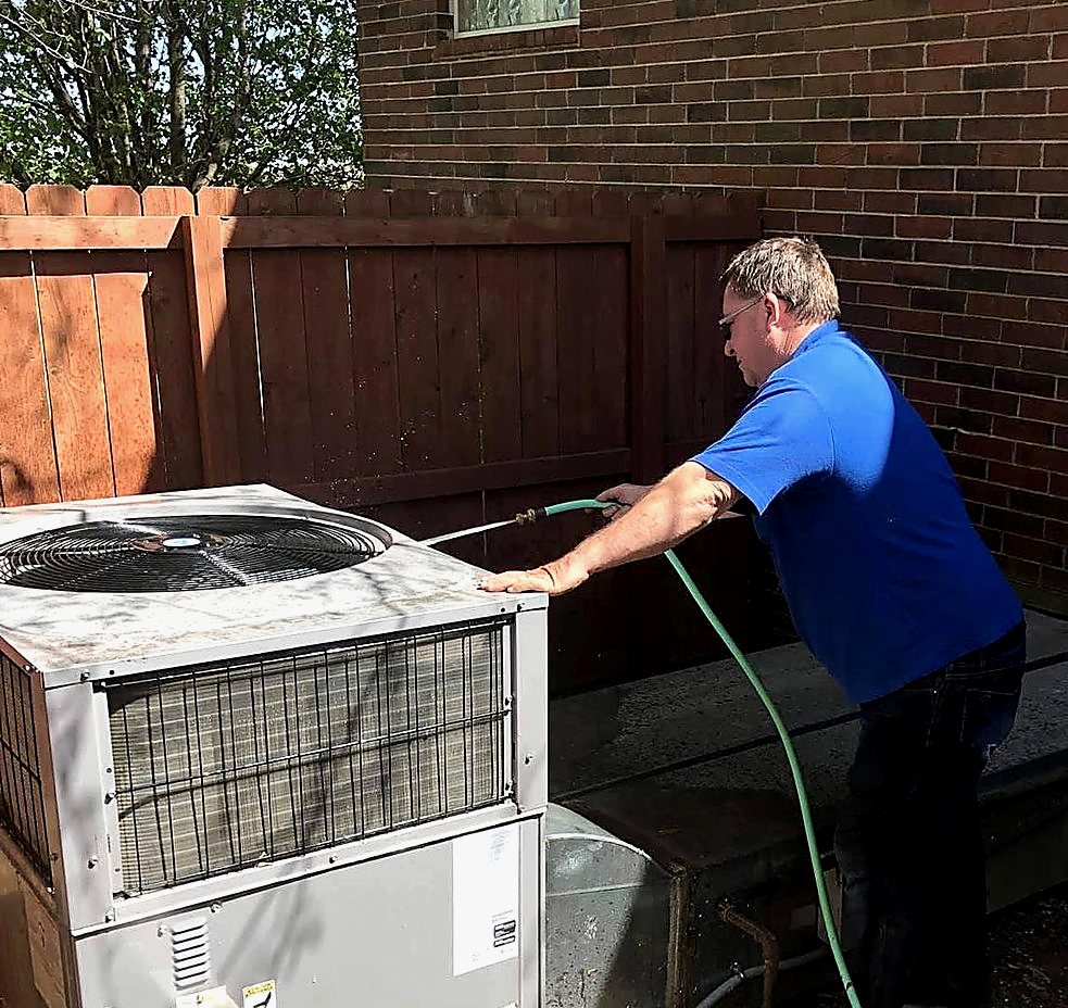 Collins Heating & Cooling servicing an outdoor condensing unit at a Harrison area home
