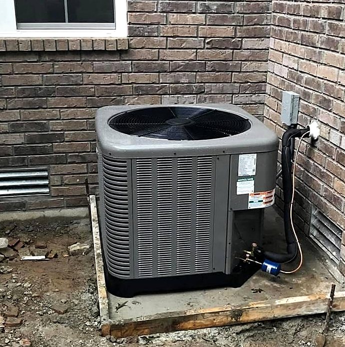 New air conditioning system on a fresh pad at a brick home